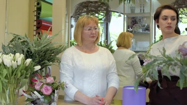 Florista ensinar assistente para fazer composição de flores — Vídeo de Stock