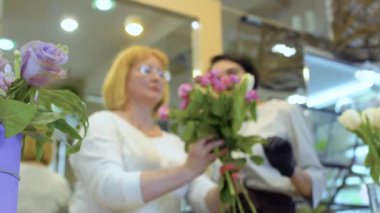 Yetişkin kadın öğrenmek çiçek buketi Çiçekçi gözetimi altında yapmak