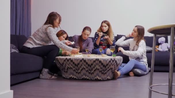 Πέντε κορίτσια τη συγκέντρωση γύρω από το τραπέζι και να τρώει με chopsticks Ασίας τροφίμων — Αρχείο Βίντεο