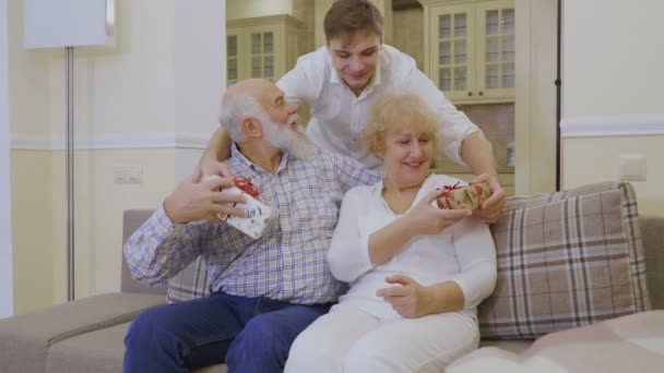 Starszy Mężczyzna Przytula Żonę Szczęśliwa Para Siedzi Kanapie Patrzy Aparat — Wideo stockowe