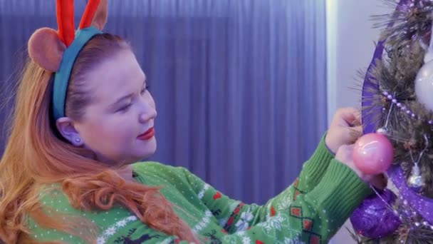 Hermosa chica de pelo rojo decorar árbol de Navidad — Vídeos de Stock