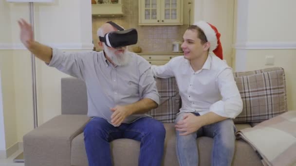 Дід використовує окуляри віртуальної реальності з сином — стокове відео