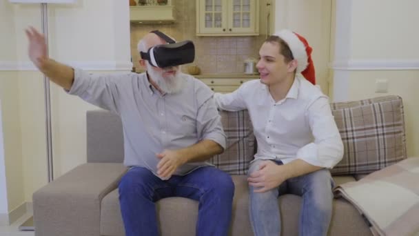 Avô usa óculos de realidade virtual com filho — Vídeo de Stock