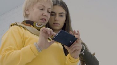 Kadınlar Smartphone'da fotoğraflara bak. İki fotoğrafçılar Fotoğraf yaptıktan sonra atış kompozisyonu tartışmak. Photostudio çalışmalarında profesyonel tasarımcılar.