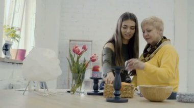 Genç ile Olgun kadın kadın photoset için tablo hazırlamak. Fotoğrafçılar beyaz fotoğraf stüdyosunda çalışıyor. 