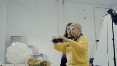 Fotoğrafçılar beyaz photo studio çalışma ve tablonun üstündeki fotoğraf yapmak. Fotoğraf şık elemanlarının yapım süreci