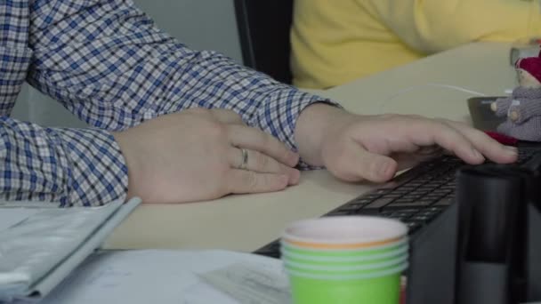 Joven escuchar música y teclear en el teclado en la oficina — Vídeo de stock