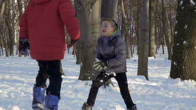İki erkek kış orman, ağır çekim kartopu oynamak