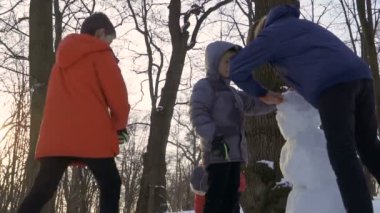 Çocuklar kardan adam birlikte kış parkta yapmak