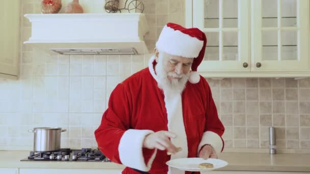 Usmívající Santa Claus Červený Kostým Klade Jednom Cookies Bílé Plotně — Stock video