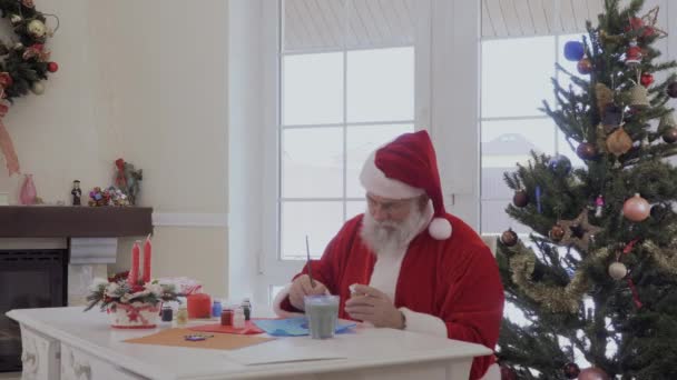 Santa Claus Sentado Cerca Ventana Las Pinturas Del Árbol Navidad — Vídeo de stock