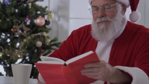 Santa Claus Een Kerst Hoed Rode Kostuum Zittend Tafel Grootvader — Stockvideo