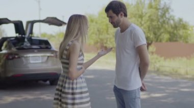Genç kendi aralarında tartışmada arka plan bulanık otomatik kapı açılması ile çift. Adam gülüyor ve ne zaman gülümseyen kız arkadaşı ona yemin ederim. Kadın ve adam kişisel sorunlarla