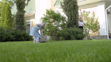 Şirin litle kız çekme cardbox th Çim bahçe üzerinde Petunya ile. Bahçe işleri yapmak için çok güzel çocuk çalışır ve yardım Anne.