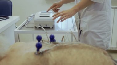 Komuta sizde klinikte elektrokardiyografi olun. İhtiyar bir adamın kalp ile ilgili bir sorun var ve kalp doktoru kontrol.