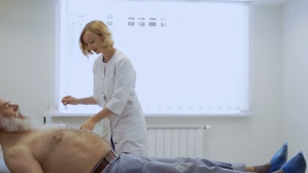 Médico Prepara Paciente Para Electrocardiografía Mujer Prepara Equipo Antes Ponerlo — Vídeo de stock