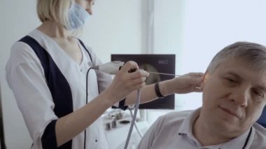 Doktor hasta kulak KBB teleskopla incelemek ve monitör ekranında bakın. Komuta sizde kontrol otolaryngologist modern kliniğinde kulağına.