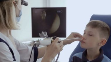 Doktor hasta burun KBB teleskopla incelemek ve monitör ekranında bakın. Küçük çocuk kontrol burnunu otolaryngologist modern kliniğinde.