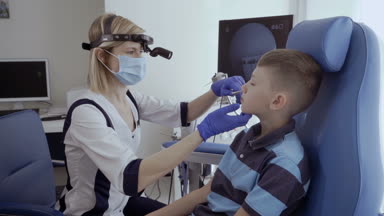 Doktor hasta burun mastar ile incelemek ve burun bak. Küçük çocuk kontrol burnunu otolaryngologist modern kliniğinde.