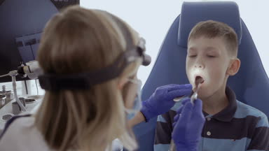 Doktor hasta boğaz KBB teleskopla incelemek ve çocuk ağız bak. Küçük çocuk kontrol otolaryngologist modern kliniğinde boğazında.