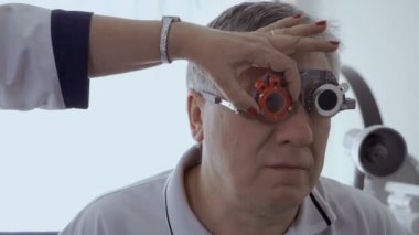 Doktor onay optik deneme çerçeve ile görme mans. Üst düzey adam kötü bir görme ve göz doktoruna modern kliniğinde iade.