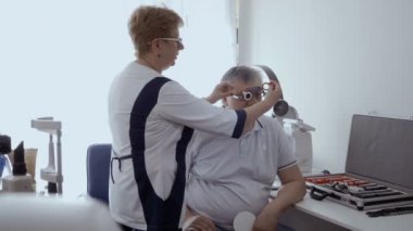 Doktor onay optik deneme çerçeve ile görme mans. Üst düzey adam kötü bir görme ve göz doktoruna modern kliniğinde iade.