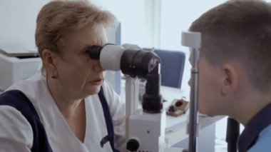 Doktor kontrol küçük çocuklar görme modern ekipmanla donatılmış. Güzel bir çocuk üzerinde düşünülmeli bakmak ve gözlerini hareket etme. Küçük çocuğun tanılama görme.