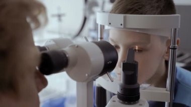 Doktor kontrol küçük çocuklar görme modern ekipmanla donatılmış. Güzel bir çocuk üzerinde düşünülmeli bakmak ve gözlerini hareket etme. Küçük çocuğun tanılama görme.