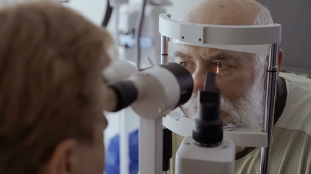 Lekarz Sprawdzić Wzrok Starszy Człowiek Nowoczesnym Wyposażeniem Stary Człowiek Wyglądają — Wideo stockowe