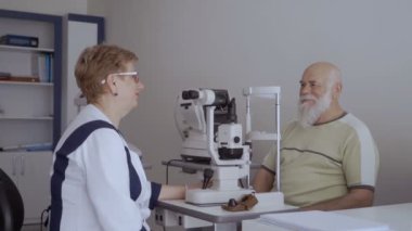 Doktor hasta ile görme kontrol prosedürü sonra konuşuyor. Erkek ve kadın açmak ve kameraya bak. Gülümseyen adam Haritayı başparmak yukarı.