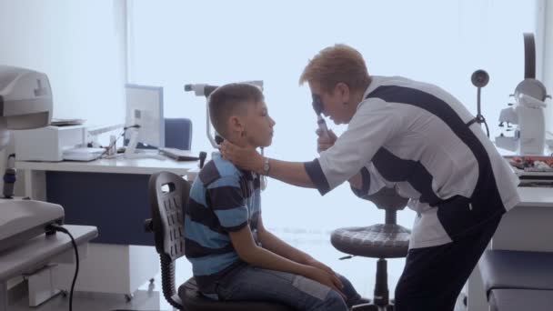 Γιατρός Ελέγχει Μάτια Του Ασθενή Λαμπτήρα Μικρό Αγόρι Από Ρεσεψιόν — Αρχείο Βίντεο