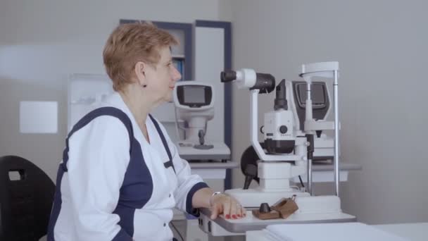 Офтальмолог Біля Оптичного Сучасного Обладнання Офісі Доросла Жінка Дивиться Камеру — стокове відео