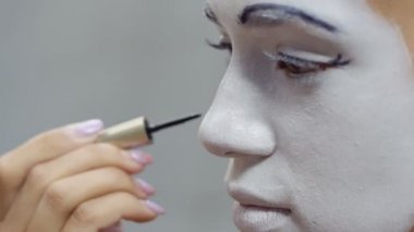 Genç kız onu yanağından iki siyah nokta koydu. Sokak MIME kentsel sokaklarda Show'da hazırlanın. Güzel genç amatör insanlar küçük sahneler gösteriyor para kazanmak.