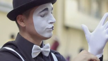 Adam MIME ellerinin üstünde beyaz eldiven koymak. Sanatçı şapka gesticulkates el ve yüz ifadeleri.