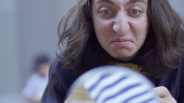 Genç adam, yüzünde beyaz boya koymak. Sokak MIME kentsel sokaklarda Show'da hazırlanın. Yakışıklı genç amatör insanlar küçük sahneler gösteriyor para kazanmak.