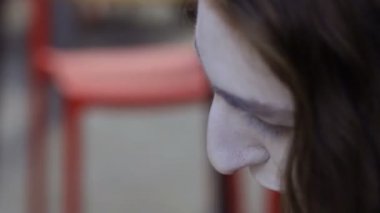 Aynaya bakarak kaşlarını siyah kalem boya genç adam. Sokak MIME kentsel sokaklarda Show'da hazırlanın. Yakışıklı genç amatör insanlar küçük sahneler gösteriyor para kazanmak.
