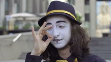 Genç şapka gösterisinde duygularını fotoğraf makinesinde Mim. Portre komik komik yüz ifadeleri ile oynama. Yakın çekim.