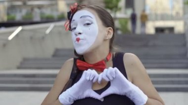 Genç kız MIME duygularını kameraya göster. Yüz ifadeleri ile oynama ve el gesticulating komik çizgi portresi. Yakın çekim.