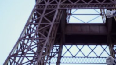 O adam MIME giymiş gömlek çıkardı ve kırmızı bere Eiffel tower yakınındaki kamera için poz. Sokak aktör komik roller oynayan ve onun yüz ifadeleri ile oynarken para kazanmak.