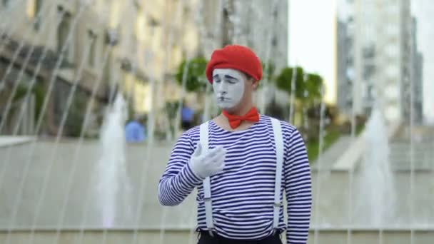 Funny man mime in red beret and stripped shirt singing at fountains background — Stock Video