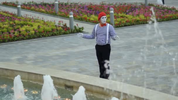 Mime в червоному береті розважається з фонтанами — стокове відео