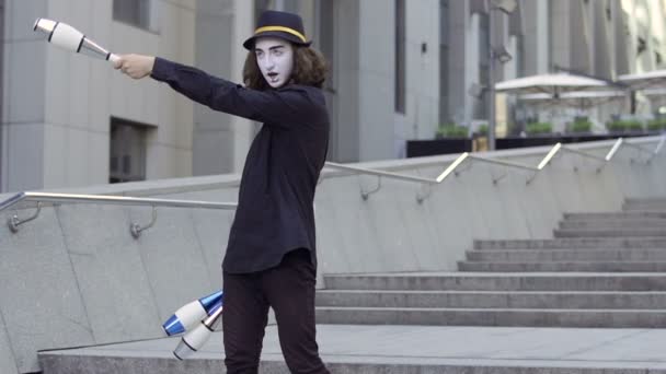 Mime hábil malabarismo pinos em pé na escada perto do centro de escritórios — Vídeo de Stock