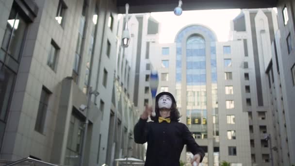 Mime en chapeau jonglant épingles à l'arrière-plan du centre de bureau — Video