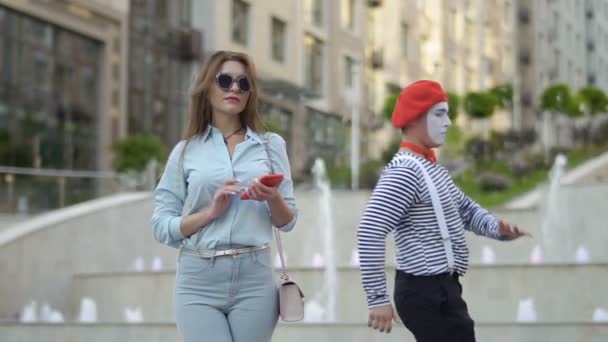 Mime는 전화를 사용 하 여 세련 된 여자 근처 재미 — 비디오