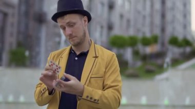 Şapka ve sarı ceket illüzyonist elinde iskambil ile