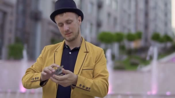 Mágico em casaco amarelo com cartas de jogo nas mãos — Vídeo de Stock