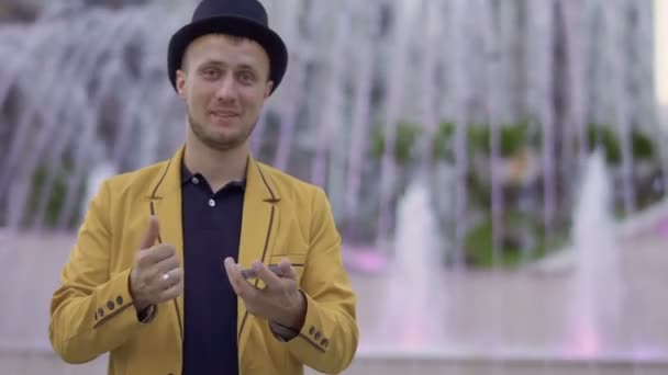 Magician in hat and yellow jacket skillfully moving playing cards in hands — Stok Video