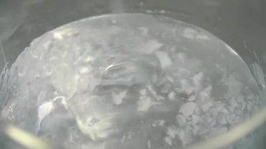 Toz ve liqiuid cam fincan içinde cam çubukla karıştırma kimyager. Toz ve sıvı deney için karıştırma bir bilim adamı. Yakın çekim.
