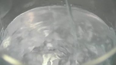 Toz ve liqiuid cam fincan içinde cam çubukla karıştırma kimyager. Toz ve sıvı deney için karıştırma bir bilim adamı. Yakın çekim.