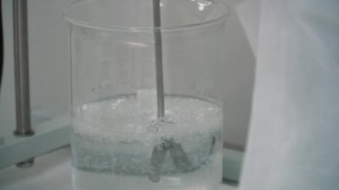 Bir cam bardak sıvı blender ile karıştırma. Sıvı bir laboratuvar deneyin. Yakın çekim.